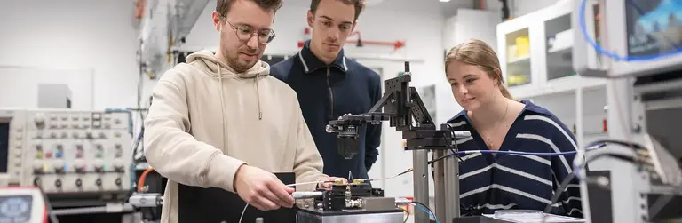Studierende im Physiklabor führen ein Experiment durch