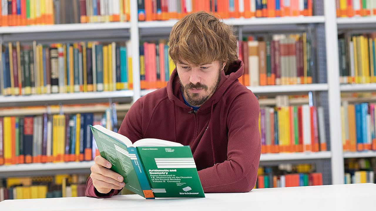 Student sitzt in der Bibliothek