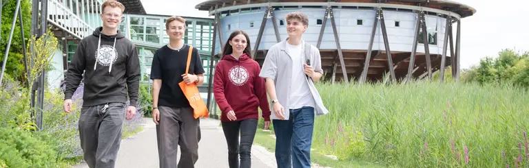 Studierende_laufend_Campus_168_gespiegelt Studierende laufen über den Campus an der Uni West