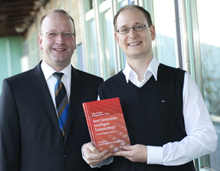 Nicht ohne Stolz präsentieren Prof. Wolfgang Minker (links) und Tobias Heinroth das Fachbuch, das die Ergebnisse des Projekts dokumentiert und jetzt in einem renommierten Wissenschaftsverlag erschienen ist